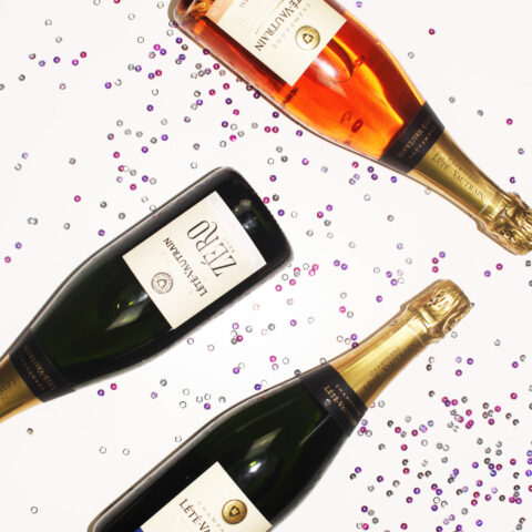 Flat lay image of champagne bottles with sequins.